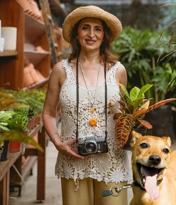 a lady standing with croton plants in a pot and a dog